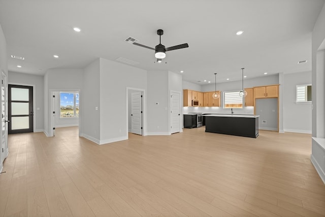 unfurnished living room with ceiling fan and light wood-type flooring