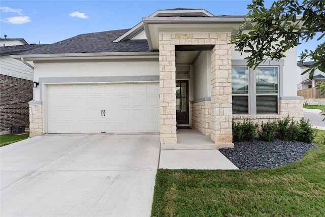 view of front of home with an attached garage, stone siding, and stucco siding