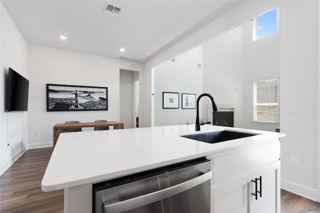 kitchen featuring sink, white cabinets, a kitchen island with sink, stainless steel dishwasher, and dark wood-type flooring