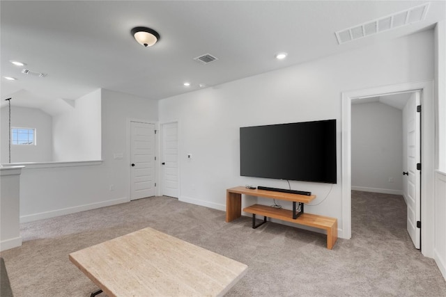 carpeted living room with visible vents and vaulted ceiling