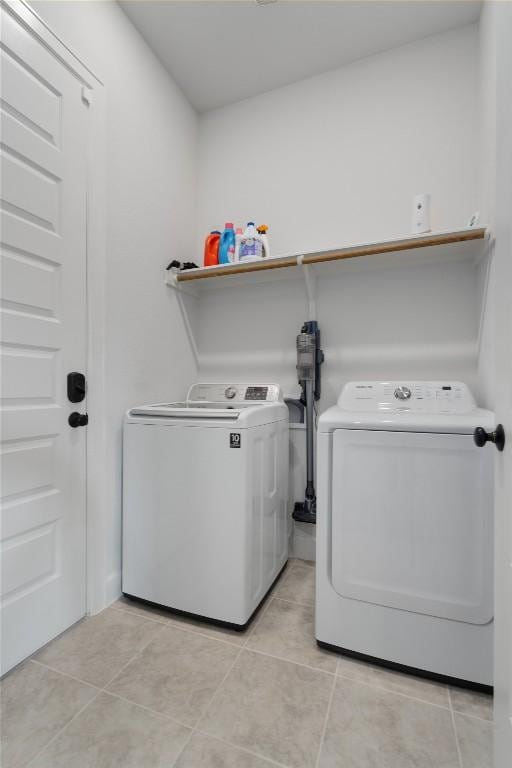 washroom with washing machine and dryer, laundry area, and light tile patterned flooring