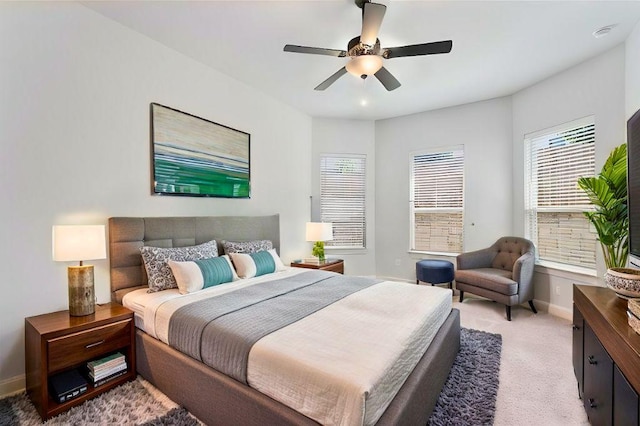 bedroom featuring light carpet, ceiling fan, and baseboards