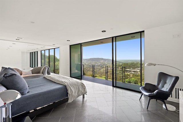 bedroom featuring tile patterned flooring, a mountain view, and a wall of windows