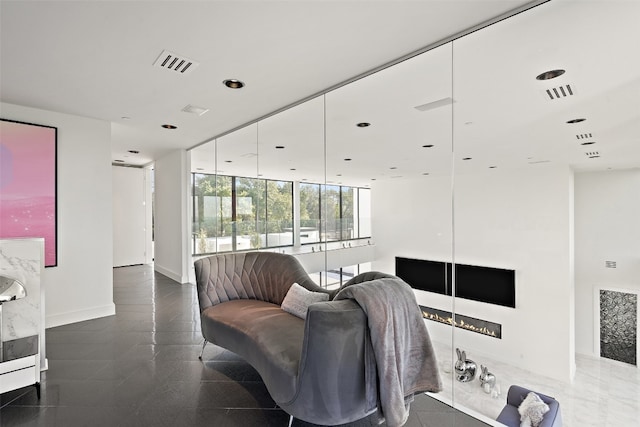 tiled living room featuring a wall of windows