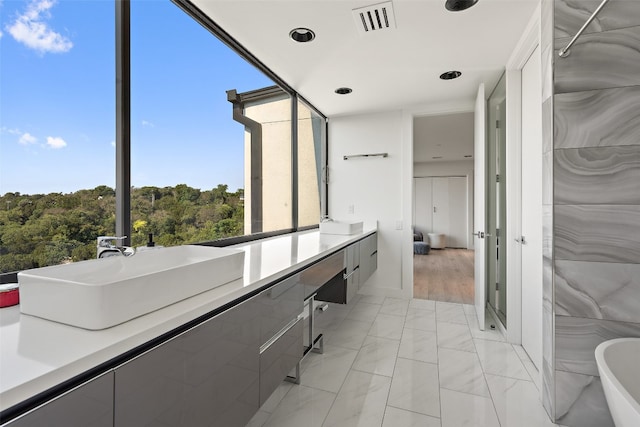 bathroom featuring hardwood / wood-style floors, a tub to relax in, a wealth of natural light, and vanity