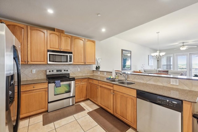 kitchen with appliances with stainless steel finishes, sink, backsplash, light tile patterned floors, and kitchen peninsula