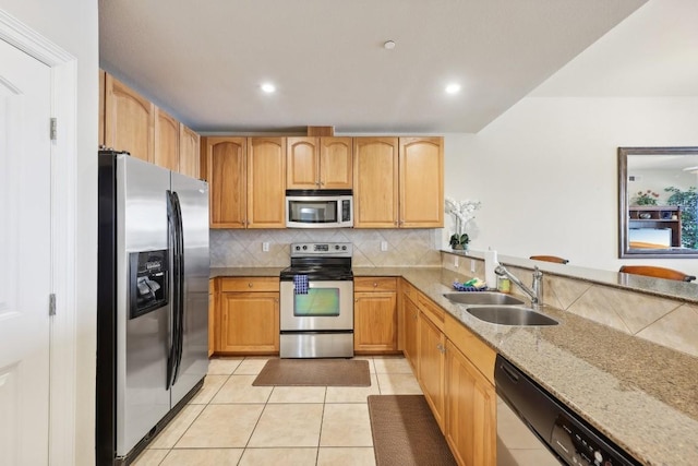 kitchen with light tile patterned flooring, appliances with stainless steel finishes, sink, decorative backsplash, and light stone counters