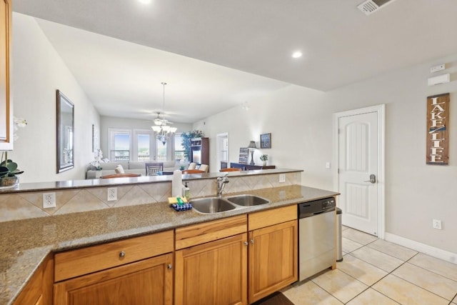 kitchen featuring sink, light stone counters, a notable chandelier, light tile patterned flooring, and stainless steel dishwasher