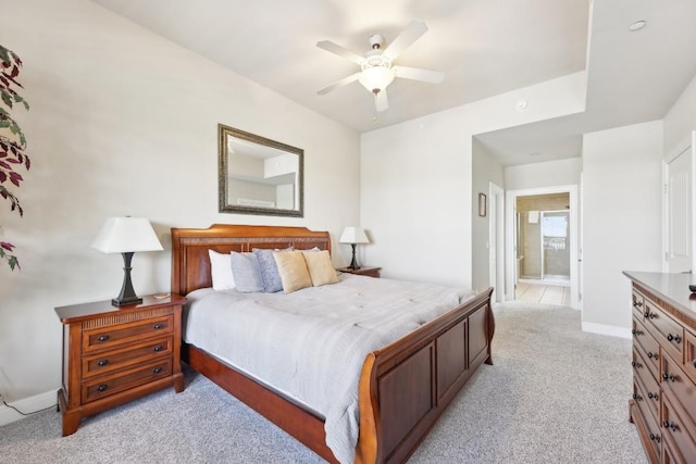 bedroom featuring ceiling fan, connected bathroom, and light carpet