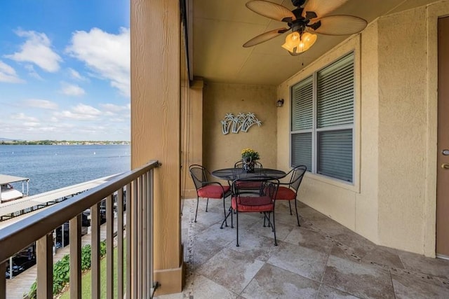 balcony with a water view and ceiling fan