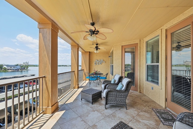 exterior space with a balcony, a water view, and ceiling fan