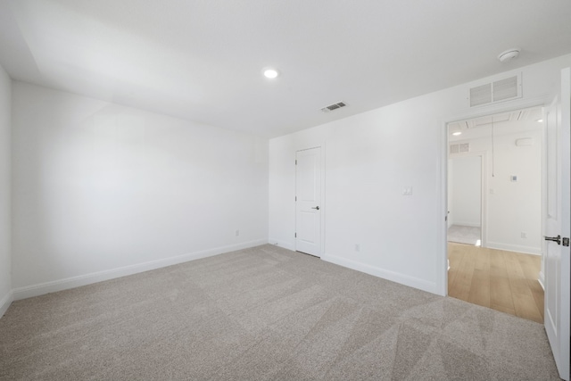 spare room featuring light carpet