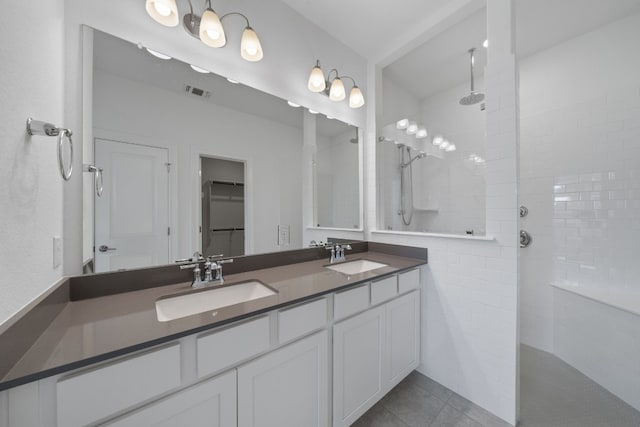 bathroom featuring tiled shower, vanity, and tile patterned floors