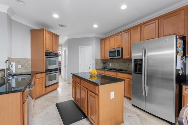 kitchen featuring sink, crown molding, appliances with stainless steel finishes, dark stone countertops, and a kitchen island