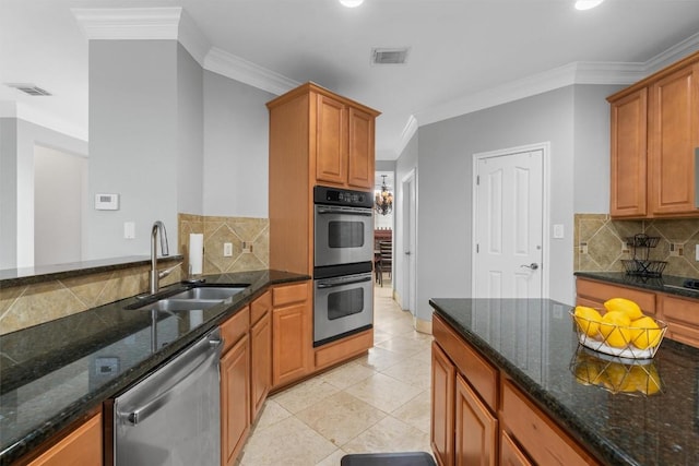 kitchen featuring ornamental molding, appliances with stainless steel finishes, sink, and dark stone countertops