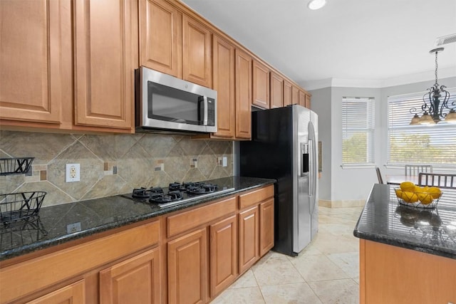 kitchen featuring pendant lighting, light tile patterned floors, dark stone countertops, stainless steel appliances, and ornamental molding