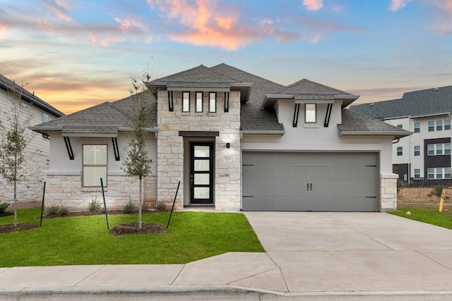 prairie-style house featuring a garage and a lawn