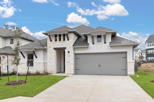 view of front of house with a garage, central AC unit, and a front lawn