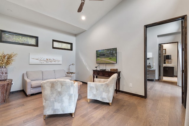 living room with lofted ceiling, ceiling fan, baseboards, and wood finished floors