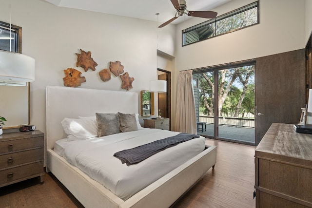 bedroom with dark wood-type flooring, access to exterior, and multiple windows