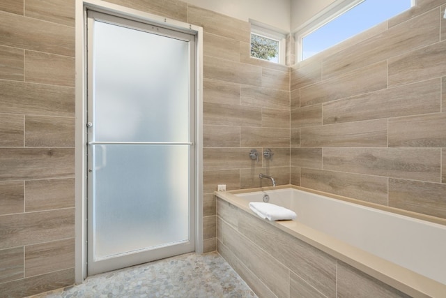 bathroom featuring a relaxing tiled tub