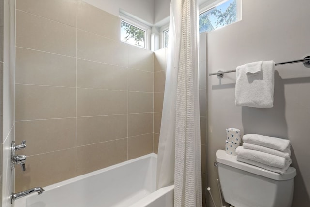 bathroom featuring shower / bathtub combination with curtain and toilet