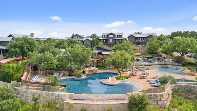 community pool featuring a patio, a community hot tub, and fence