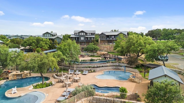 community pool with a patio area and a hot tub