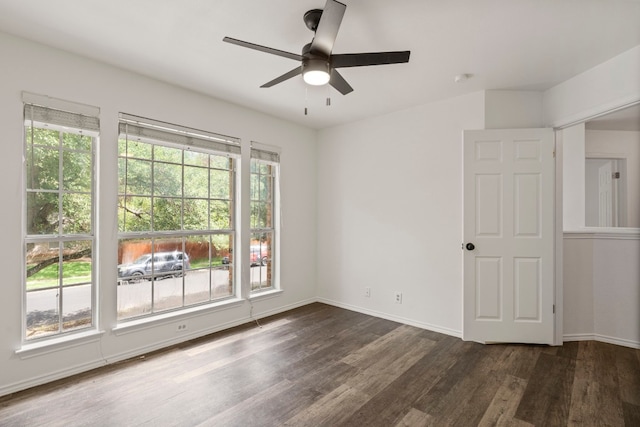 spare room featuring dark hardwood / wood-style flooring, a wealth of natural light, and ceiling fan