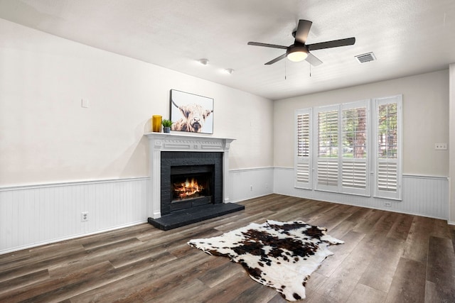 unfurnished living room with ceiling fan, a brick fireplace, and wood-type flooring