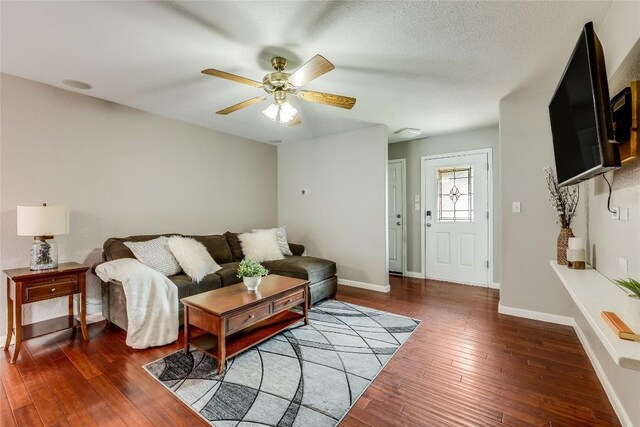 living room featuring dark wood-type flooring and ceiling fan