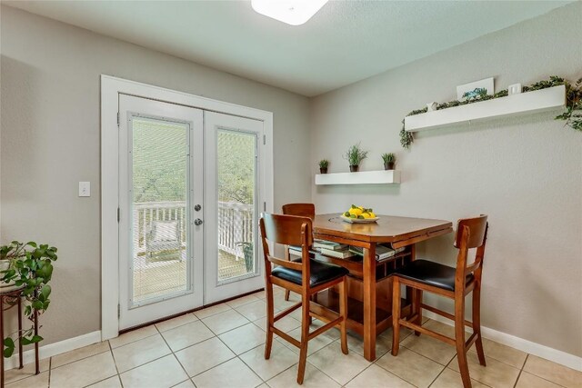 dining space with light tile patterned floors and french doors