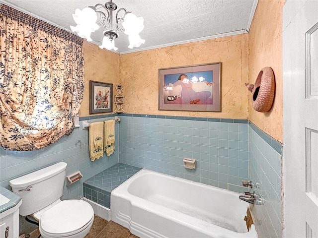 bathroom with vanity, tile walls, toilet, and a textured ceiling