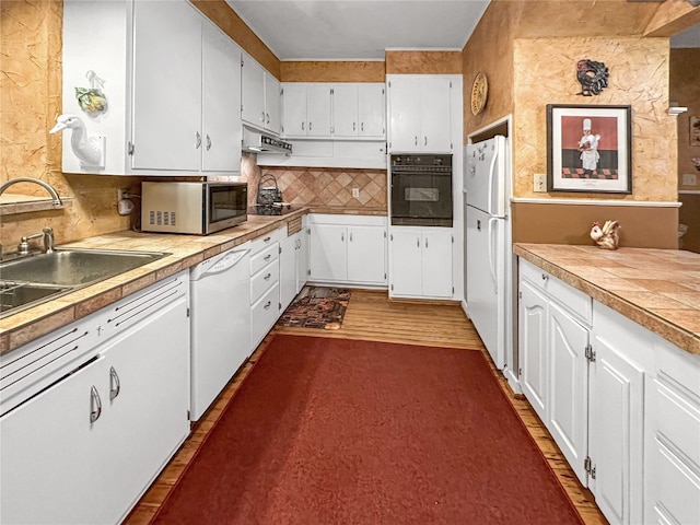 kitchen with dark wood-type flooring, white appliances, and white cabinets