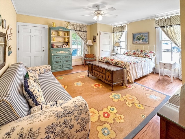 bedroom with ornamental molding, hardwood / wood-style floors, and ceiling fan