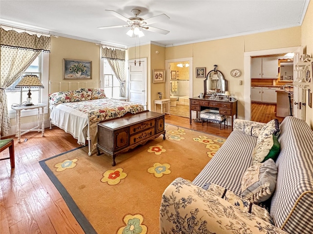 bedroom with connected bathroom, multiple windows, light hardwood / wood-style flooring, and ornamental molding