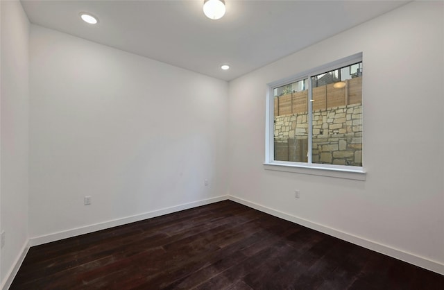 spare room featuring recessed lighting, baseboards, and dark wood-style floors