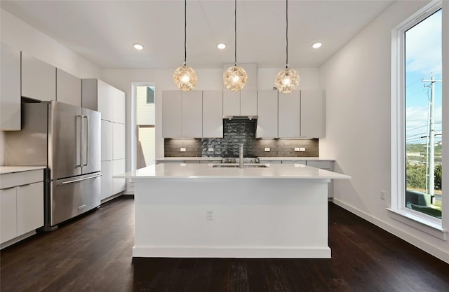 kitchen featuring light countertops, modern cabinets, backsplash, and high quality fridge