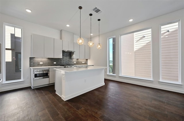 6821 Wolfcreek Pass Unit 15, Austin, TX 78749 - kitchen with stainless steel oven, healthy amount of natural light, light countertops, dark wood finished floors, and recessed lighting
