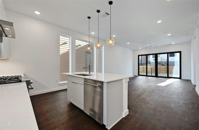 kitchen with decorative light fixtures, dark hardwood / wood-style flooring, stainless steel appliances, a kitchen island with sink, and white cabinets