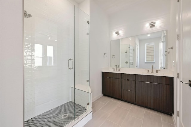 full bath featuring double vanity, a sink, and a shower stall
