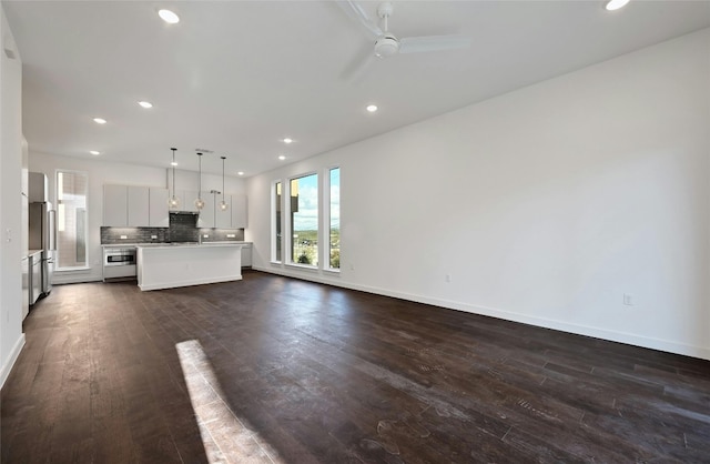 6821 Wolfcreek Pass Unit 15, Austin, TX 78749 - unfurnished living room featuring dark wood finished floors, recessed lighting, ceiling fan, and baseboards
