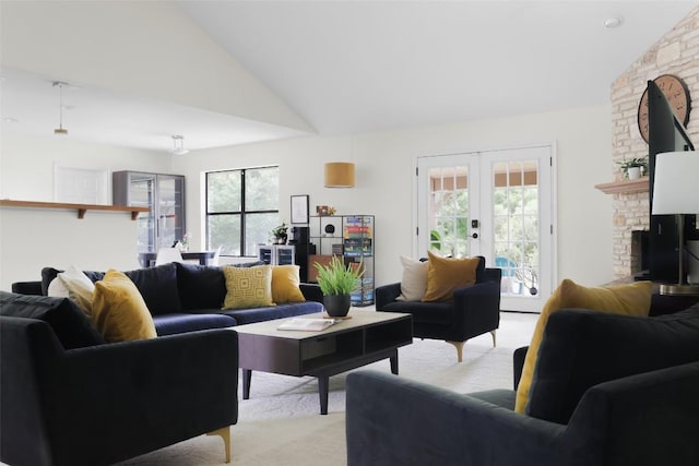 living room with french doors, plenty of natural light, a fireplace, and light colored carpet