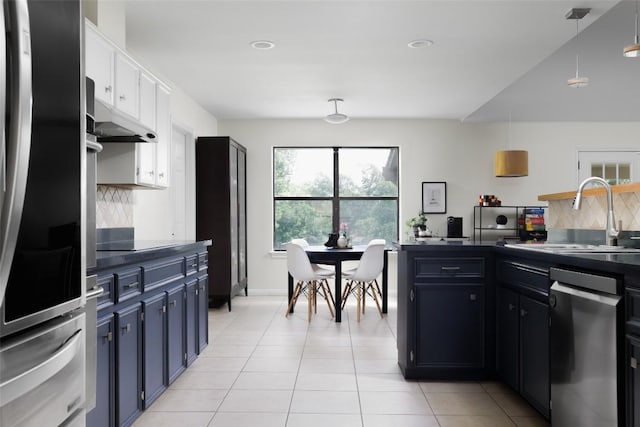 kitchen featuring tasteful backsplash, dark countertops, black electric stovetop, a sink, and light tile patterned flooring