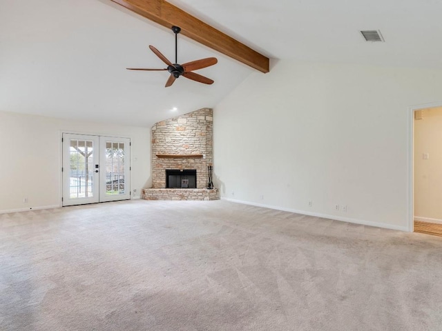 unfurnished living room with beamed ceiling, carpet, french doors, a fireplace, and high vaulted ceiling