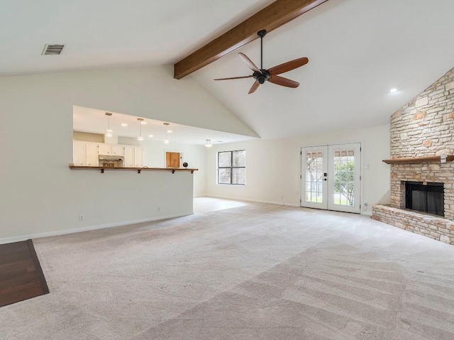 unfurnished living room featuring high vaulted ceiling, a stone fireplace, light carpet, visible vents, and beam ceiling