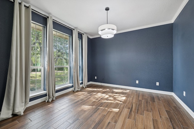 empty room featuring ornamental molding and wood-type flooring