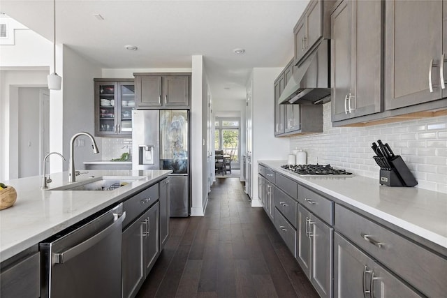 kitchen with decorative light fixtures, sink, decorative backsplash, stainless steel appliances, and dark wood-type flooring