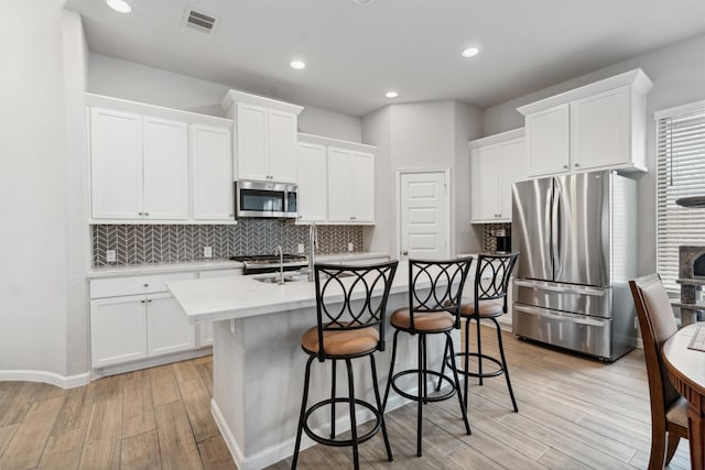 kitchen featuring white cabinets, appliances with stainless steel finishes, and light wood-type flooring