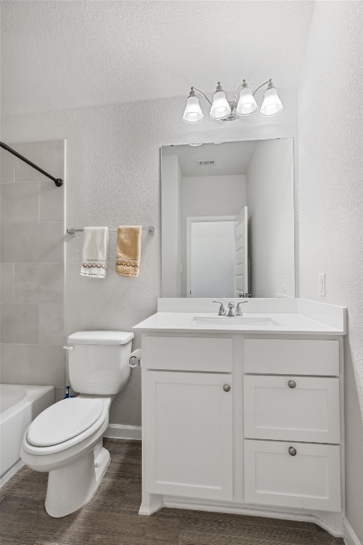 full bathroom with wood-type flooring, vanity, toilet, and washtub / shower combination